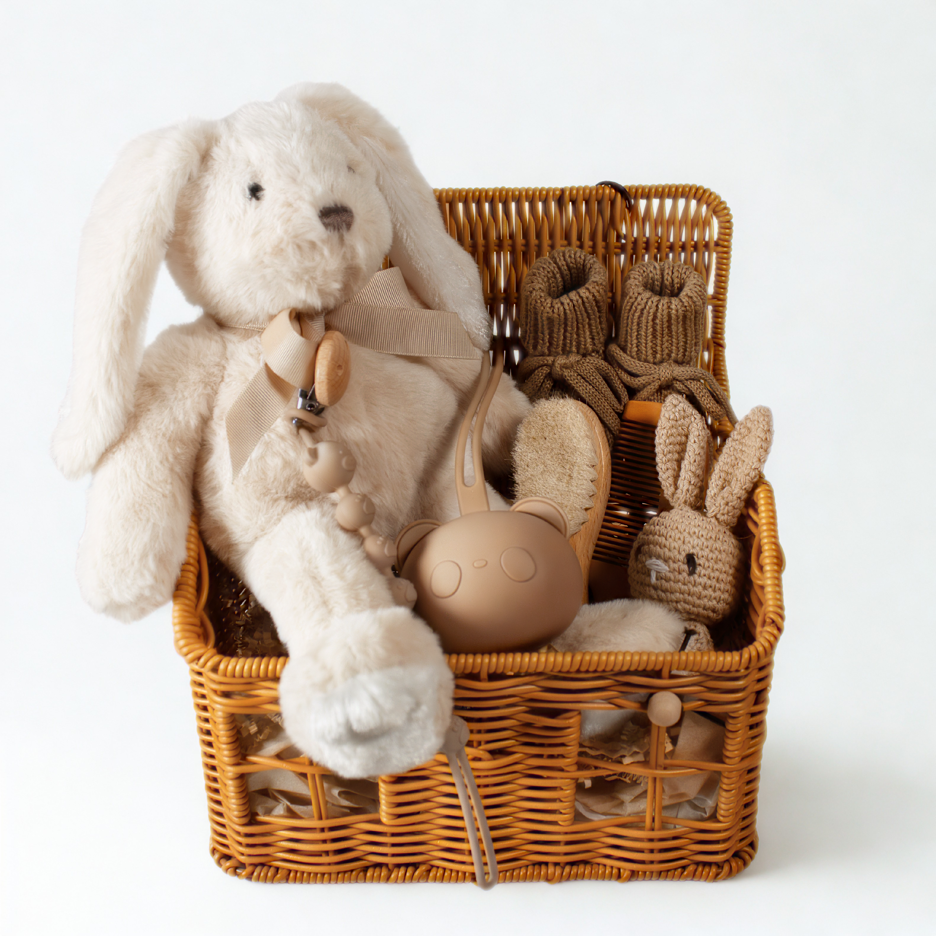 Neutral newborn baby gift basket with plush bear, bunny rattle, brush and comb, pacifier clip, pacifier holder and baby socks.